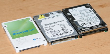Ein SSD-Speicher (links) neben zwei herkömmlichen PATA-Festplatten im 2,5